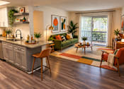 Thumbnail 4 of 20 - A modern kitchen with a green couch and wooden floors.