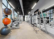 Thumbnail 20 of 31 - a gym with weights and other exercise equipment in a building with large windows