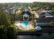 Thumbnail 34 of 36 - a aerial view of a swimming pool in front of a house and a lake