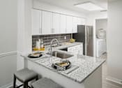 Thumbnail 12 of 36 - a kitchen with white cabinets and a granite counter top