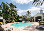 Thumbnail 23 of 36 - a swimming pool in front of a hotel with palm trees