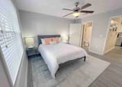 Thumbnail 18 of 24 - A bedroom with a bed, nightstand, and a ceiling fan.