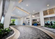 Thumbnail 7 of 30 - an office lobby with windows and a walkway with plants at Saba Pompano Beach, Pompano Beach, 33062