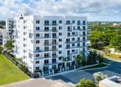 Thumbnail 2 of 30 - an aerial view of a white apartment building with grass and trees at Saba Pompano Beach, Pompano Beach, 33062