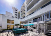 Thumbnail 6 of 30 - a large white building with a pool and umbrellas at Saba Pompano Beach, Pompano Beach, 33062