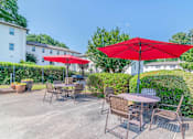 Thumbnail 3 of 18 - a patio with tables and umbrellas at Avondale Station Apartments, Decatur