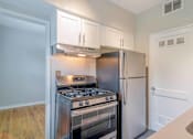 Thumbnail 7 of 18 - a kitchen with white cabinets and stainless steel appliances at Avondale Station Apartments, Decatur, Georgia