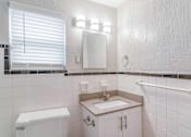 Thumbnail 10 of 18 - a bathroom with a toilet sink and mirror at Avondale Station Apartments, Decatur, GA