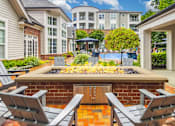 Thumbnail 14 of 20 - A backyard with a fire pit and chairs.