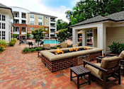 Thumbnail 15 of 20 - A patio with a fire pit and chairs.