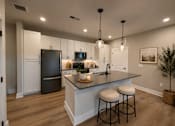 Thumbnail 4 of 11 - A kitchen with a black refrigerator and white cabinets.