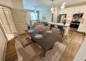 Thumbnail 24 of 54 - A dining room with a table set for two and chairs surrounding it.