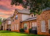 Thumbnail 67 of 69 - a row of brick houses with green grass and a cloudy sky