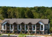 Thumbnail 64 of 70 - an aerial view of an apartment building with a forest in the background