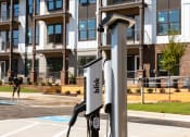 Thumbnail 54 of 70 - 1-Bedroom Apartments in Belmont, NC - The Banks Apartments - Electric Vehicle Charging Station in Parking Lot of Apartment Complex.
