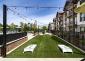 Thumbnail 51 of 70 - a grassy courtyard with two white tables and a fence