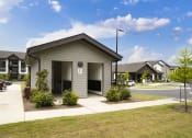 Thumbnail 56 of 70 - a small grey building with a sidewalk in front of a street