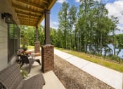 Thumbnail 50 of 70 - a covered porch with a view of a lake and trees