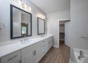 Thumbnail 32 of 54 - a white bathroom with two sinks and a mirror
