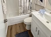 Thumbnail 14 of 38 - A bathroom with a white sink, toilet, and a shower with a curtain.