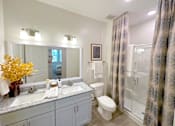Thumbnail 16 of 23 - A bathroom with a white sink, toilet, and a mirror.