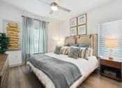 Thumbnail 7 of 24 - a bedroom with a bed and a ceiling fan