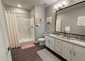 Thumbnail 14 of 48 - A bathroom with a toilet, sink, and shower.