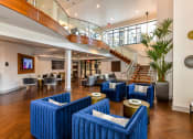 Thumbnail 20 of 58 - a large room with blue chairs and a staircase in the background