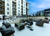 Thumbnail 39 of 58 - a patio with chairs and a coffee table in front of an apartment building