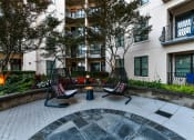 Thumbnail 43 of 58 - a courtyard with two swing chairs and a small table in front of an apartment building