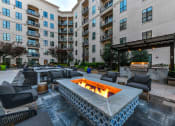 Thumbnail 41 of 58 - an outdoor patio with a fire pit and lounge chairs