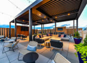 Thumbnail 49 of 58 - a roof top patio with a couch and chairs