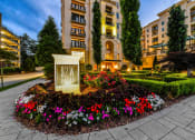 Thumbnail 56 of 58 - a sign in the middle of a flower garden in front of an apartment building