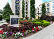 Thumbnail 52 of 58 - an apartment building with a sign and flowers in front of it