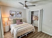 Thumbnail 13 of 38 - A bedroom with a bed, nightstand, and a ceiling fan.