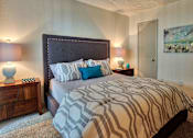 Thumbnail 12 of 35 - A bedroom with a large bed and a painting on the wall.