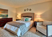 Thumbnail 10 of 35 - A bedroom with a large bed and a smaller bed with a white chair beside it.