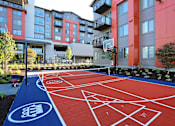 Thumbnail 18 of 27 - a basketball court in front of an apartment complex