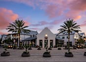 Thumbnail 48 of 54 - A building with a triangular facade is surrounded by palm trees and small plants.