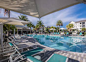 Thumbnail 47 of 54 - A large outdoor swimming pool with sun loungers and umbrellas.