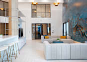 Thumbnail 8 of 29 - A modern living room with a white sofa and a bar area.