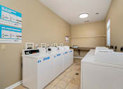 Thumbnail 18 of 22 - A laundromat with rows of washers and dryers.