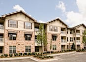 Thumbnail 16 of 18 - Apartment building with a parking lot in front.