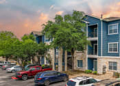 Thumbnail 30 of 31 - an apartment building with cars parked in front of it