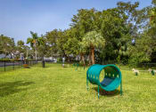 Thumbnail 23 of 34 - a green seesaw in a park with trees at L'Estancia, Sarasota, FL, 34231