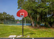 Thumbnail 25 of 34 - a basketball hoop on a pole in front of a tennis court at L'Estancia, Sarasota, 34231