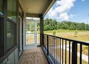 Thumbnail 21 of 50 - a covered porch with a view of a field and a door