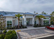 Thumbnail 2 of 31 - A modern building with a red car parked in front.