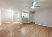Thumbnail 6 of 30 - A room with a ceiling fan and wooden flooring.