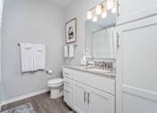 Thumbnail 21 of 24 - A white bathroom with a toilet, sink, and mirror.